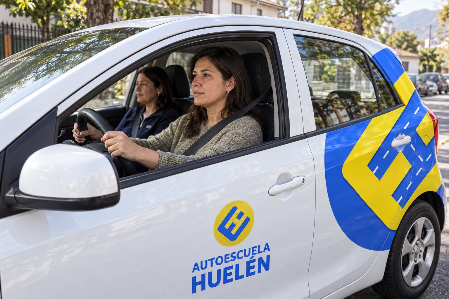 Una alumna adulta al volante del auto de Huelén, con la instructora a su lado.