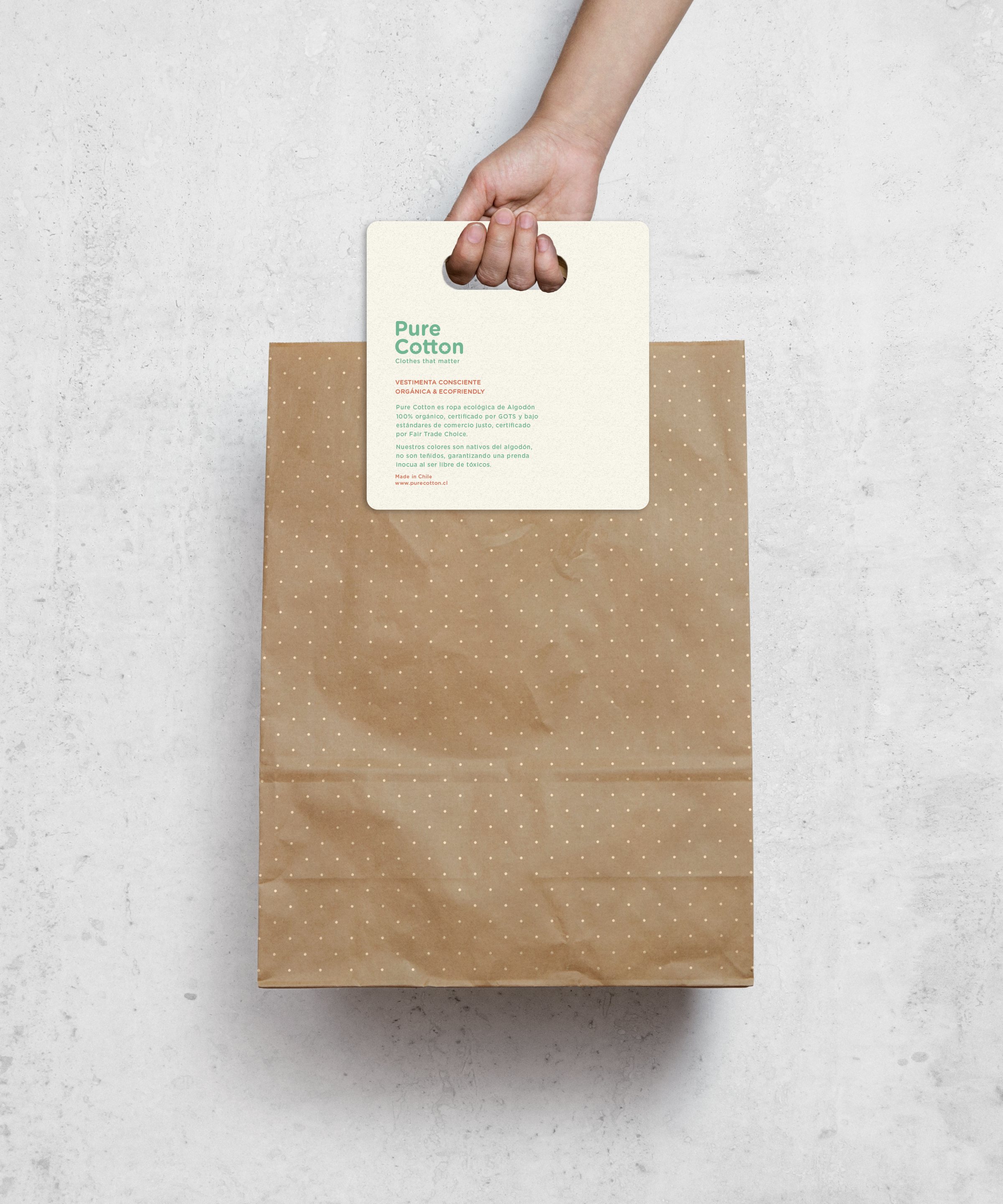 Bolsa de papel kraft con trama de puntos y manilla de cartón con el logotipo.